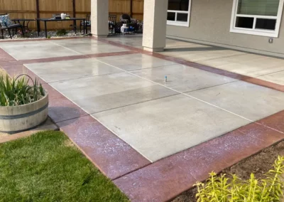 A concrete patio extension with a colored concrete border