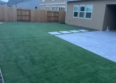 backyard with artificial turf and new patio